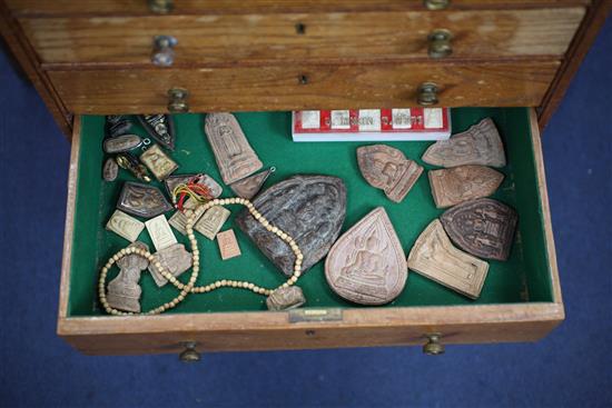 A collection of Buddhist terracotta amulets, chest 82cm